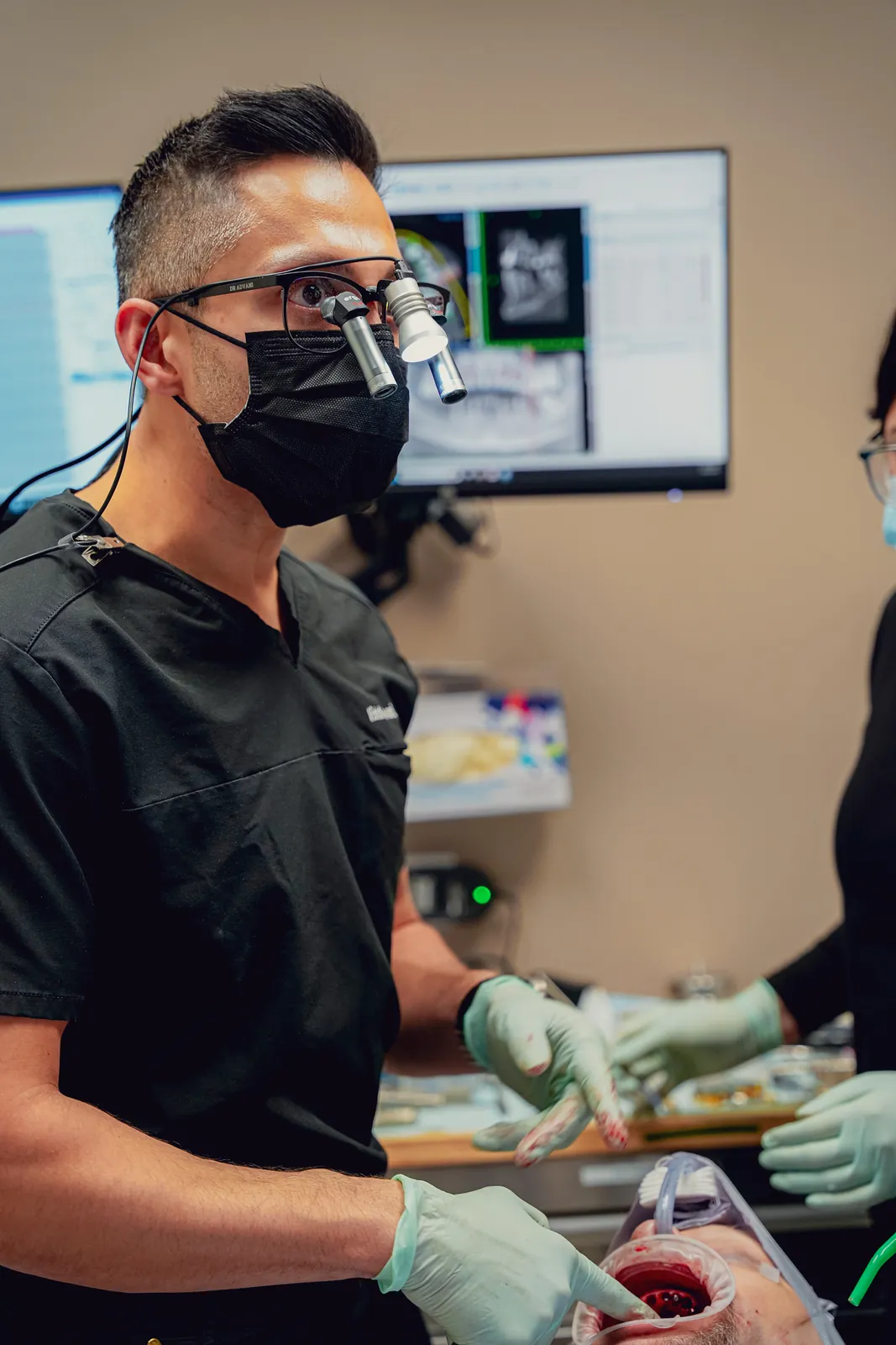 Dr. Vishal Advani performing a procedure with magnifying loupes