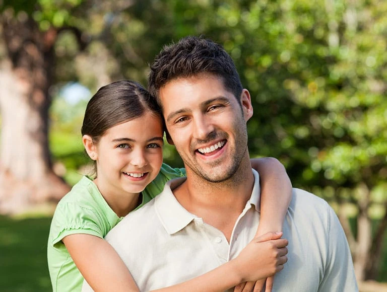 Smiling father and daughter outdoors