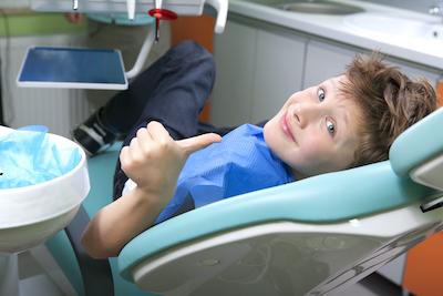 Child giving a thumbs up during dental check up and examination at Elk Grove Smile Center
