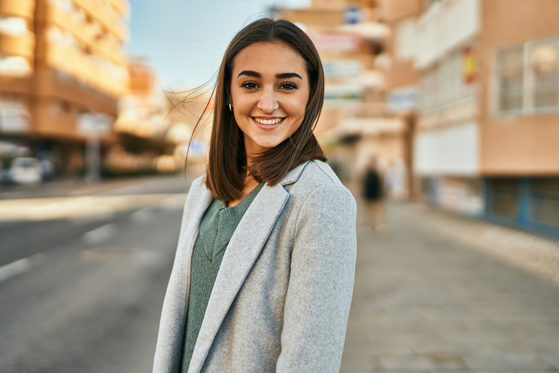 A toddler sitting on a parent's lap in a pediatric clinic, with the parent gently soothing the child's gums.